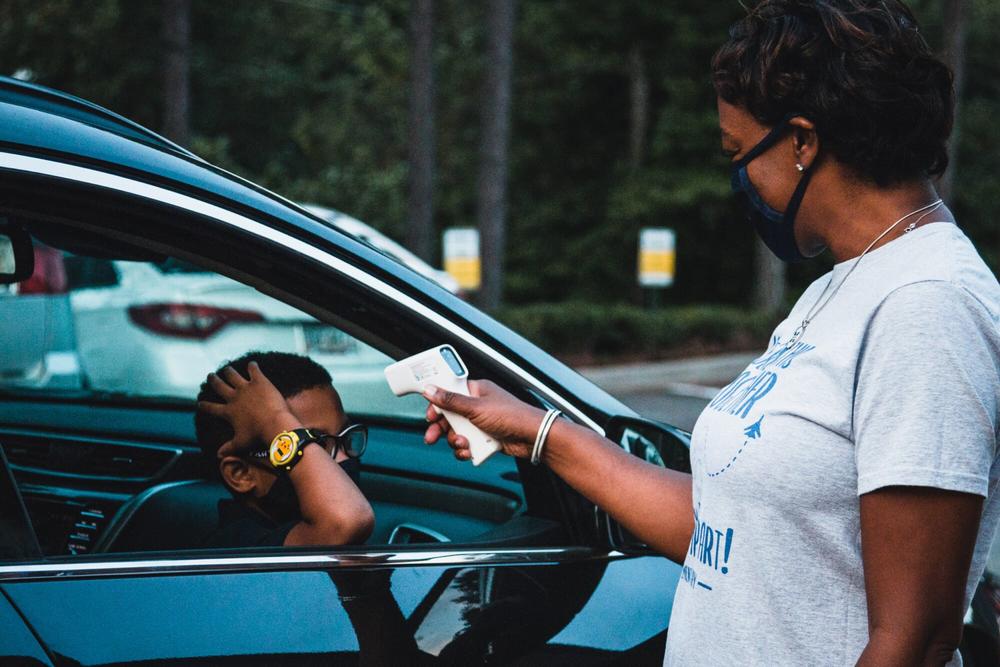 A staff member at Lockheed Elementary in Marietta checks a student’s temperature on the first day of school. 