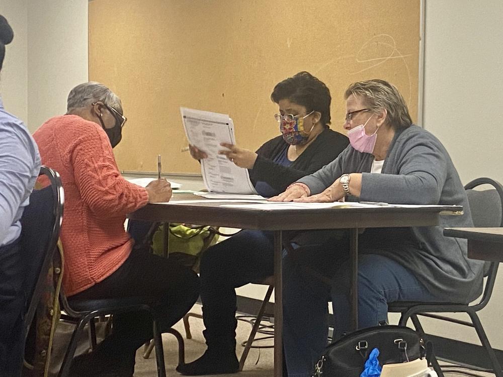 A group of election officials sit at a table in Clayton County to process ballots.