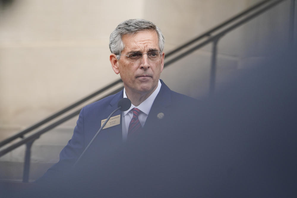 A photo of Brad Raffensperger speaking outside of the state Capitol.