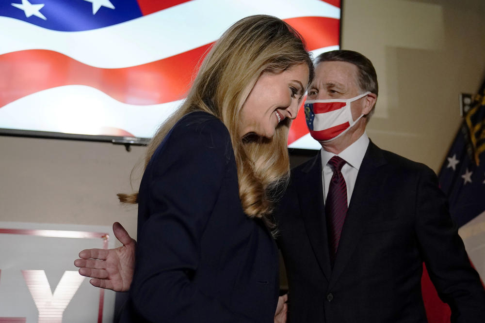 Republican candidates for U.S. Senate Sen. David Perdue leads Sen. Sen. Kelly Loeffler, off the stage during a campaign rally on Friday, Nov. 13, 2020, in Cumming, Ga. Perdue and Democratic candidate Jon Ossoff are in a runoff election for the Senate seat in Georgia.