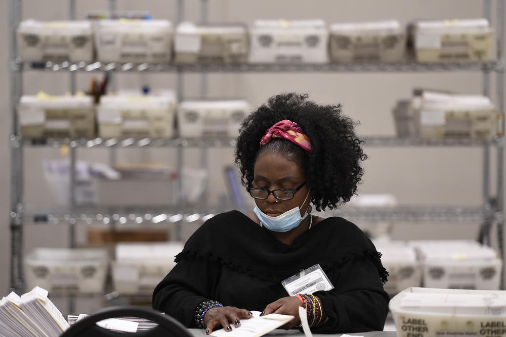 Cobb County Election officials handle ballots during an audit, Monday, Nov. 16, 2020, in Marietta, Ga. A hand tally of the nearly 5 million votes cast in the presidential race in Georgia has entered its fourth day Monday.