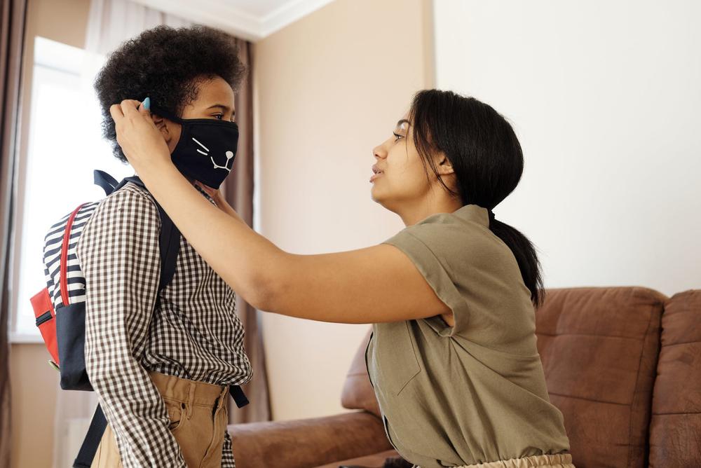 Mother putting mask on child