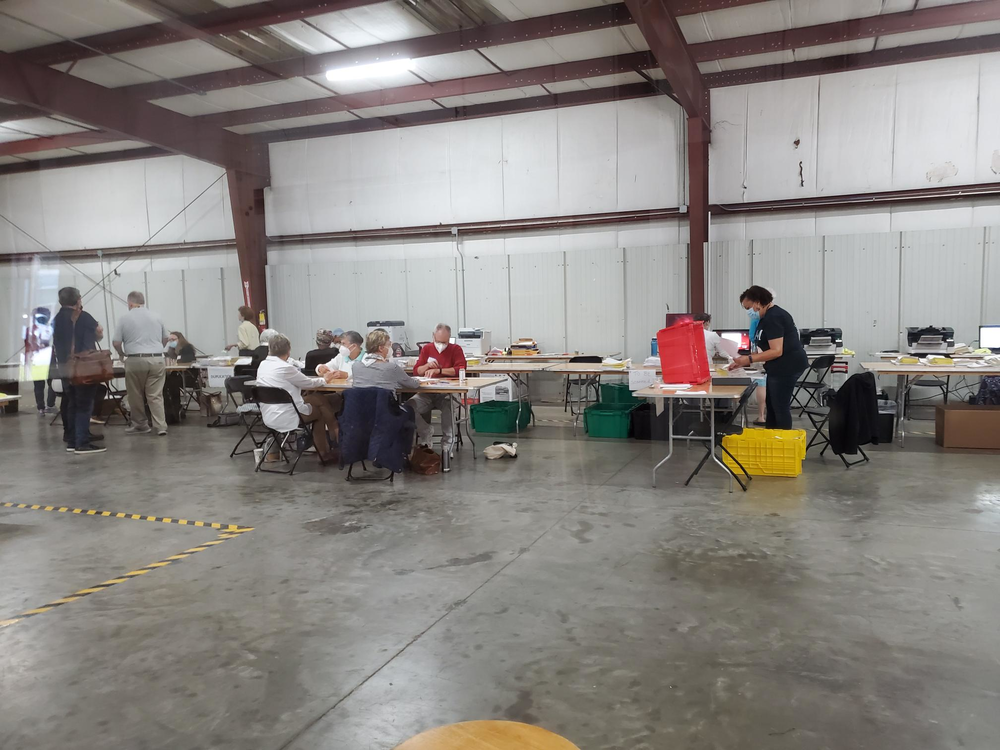 Ballots are counted at a series of tables inside of a large room in Savannah, Georgia.