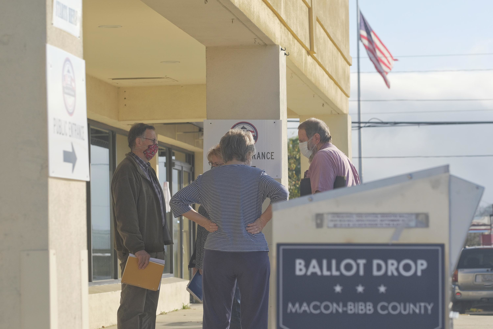 Poll watchers huddle in front of the Bibb County Board of Elections before the start of the Georgia risk-limiting audit of the presidential vote Friday.
