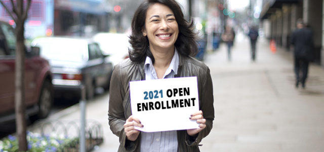 Woman holding Open Enrollment 2021 sign