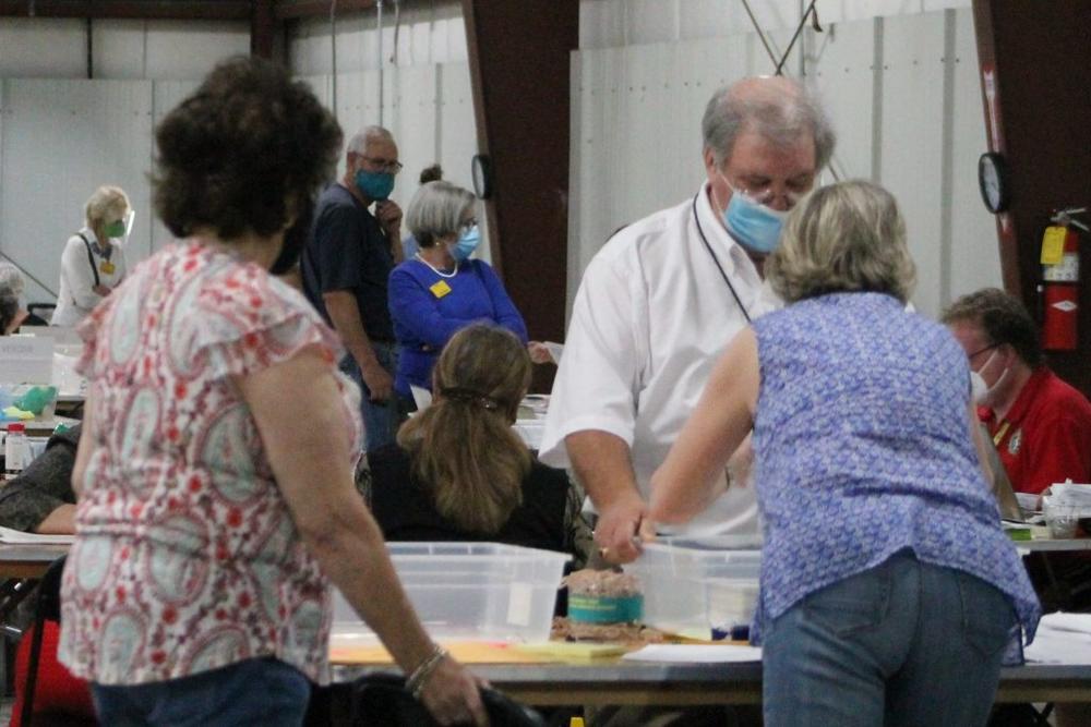 Billy Wooten, right side behind table, helps two workers at a table where ballots had been counted. Wooten was in charge of the audit operations for Chatham County.