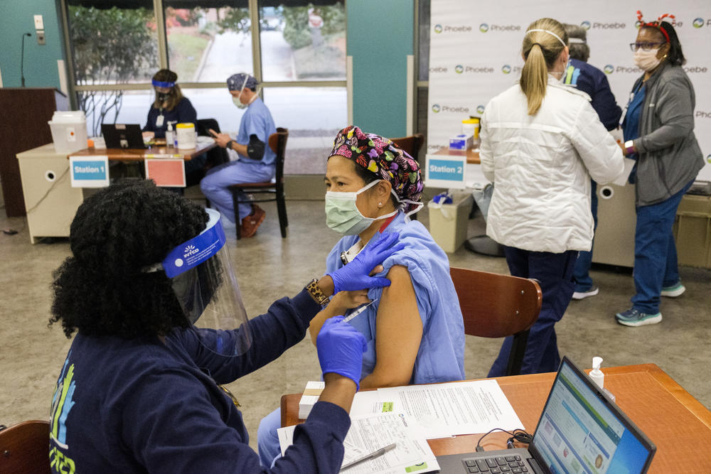 Operating room nurse Merle Santos receives the coronavirus vaccine Thursday at Phoebe Putney Memorial Hospital in Albany. 
