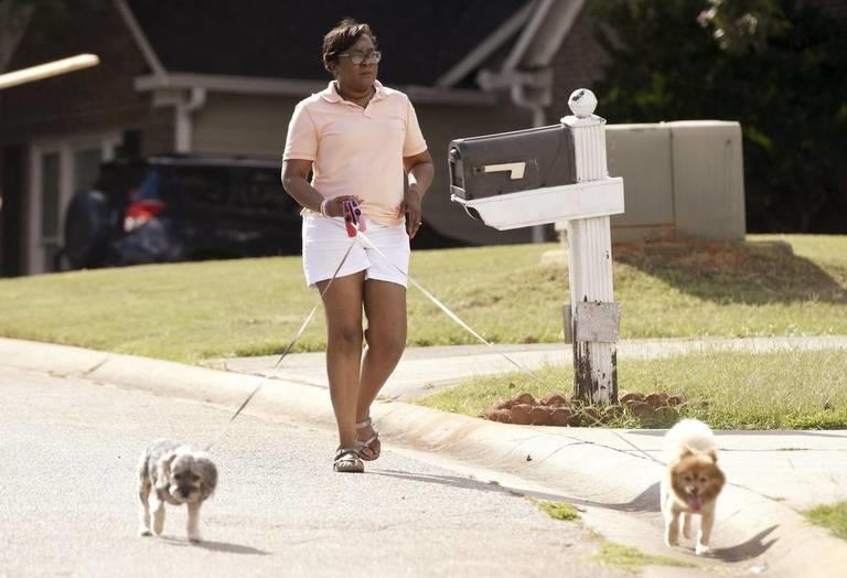 Arthena Caston walks her dogs around her neighborhood in North Macon. Caston, 54, has been diagnosed with early onset dementia.