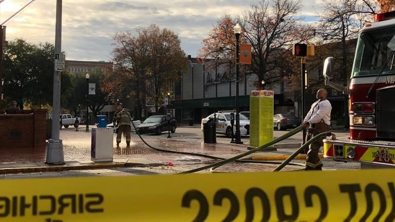  Firefighters wash blood off the sidewalk at the corner of Third and Cherry streets in the hours after a middle-of-the-night shooting in downtown Macon.