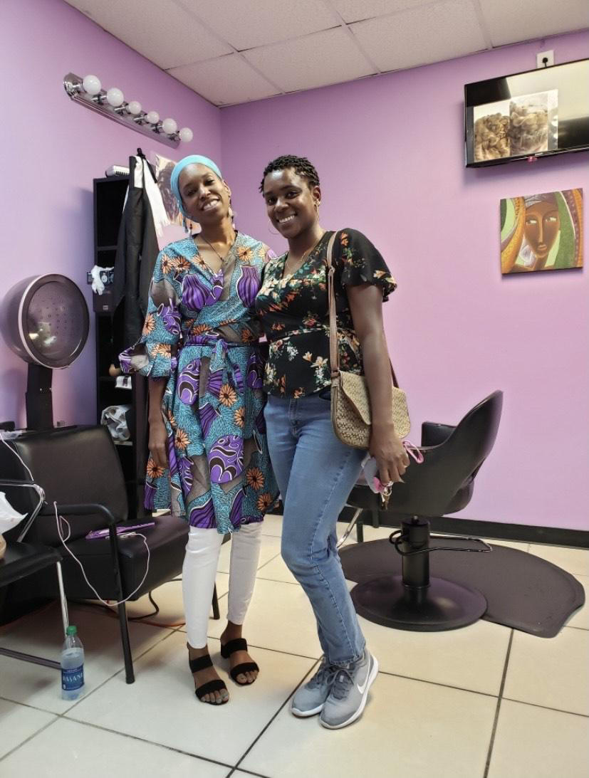 Kareemah Hanifa, left, stands with a patron of her Marietta hair salon in 2019.