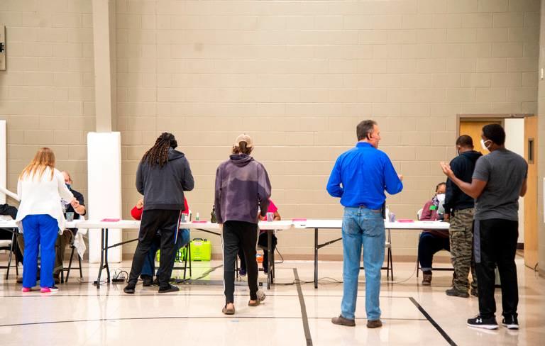 Voters stand in line inside a polling location.