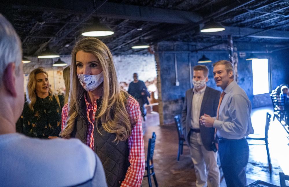 Sen. Kelly Loeffler, wearing a mask below her nose, speaks to a crowd inside a pub.