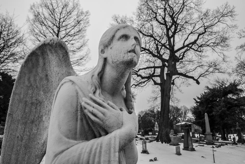 A statue of an angel in a graveyard