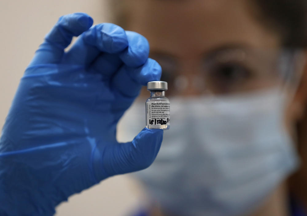 A nurse holds a vial of Pfizer's COVID-19 vaccine