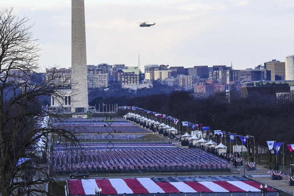 A helicopter carrying the president flies over the National Mall as the inauguration is set up.