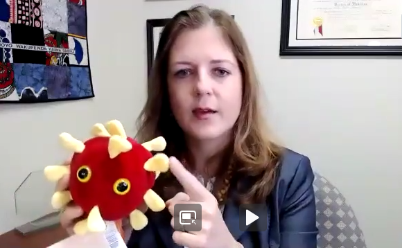 Dr. Colleen Kraft holds a stuffed coronavirus.