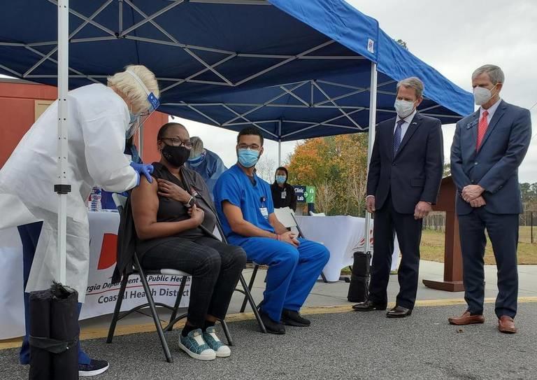 Tammi Brown, Chatham County Health Department Nurse Manager, was among the first in Georgia to receive the vaccine against COVID-19, as Memorial University Medical Center emergency room nurse David Wilson awaits another dose and Gov. Brian Kemp and State Sen. Ben Watson look on.