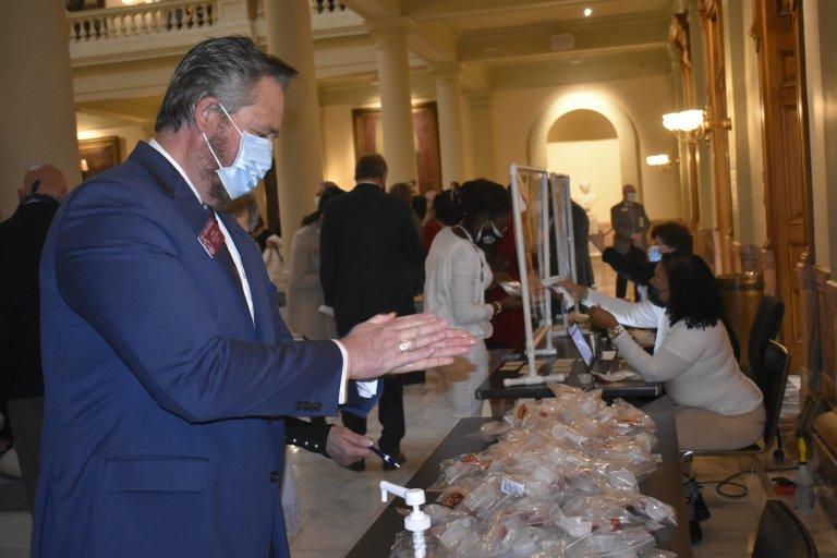 Rep. Greg Morris, a Republican from Vidalia, sanitizes his hands as lawmakers prepare for their first day of mandatory testing during the 2021 legislative session.