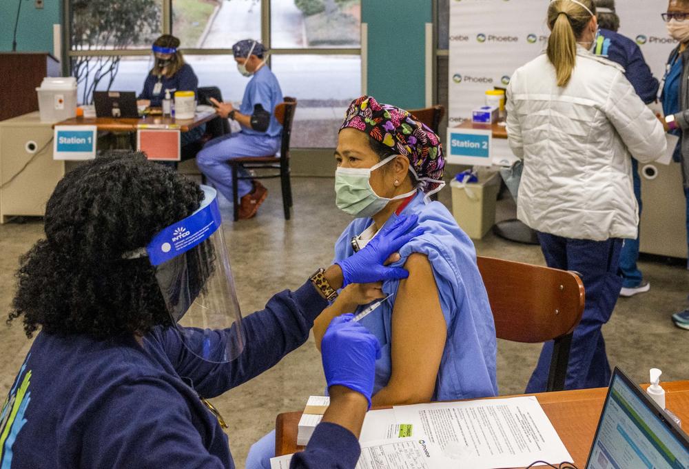 Merle Santos, an operating room nurse at Phoebe Putney Medical Center in Albany, gets a first dose of the COVID-19 vaccine on Dec. 17, 2020. 