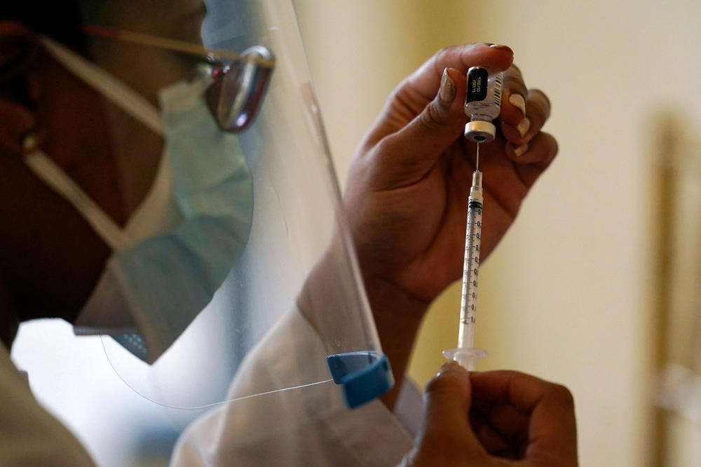 A Walgreens pharmacist prepares a syringe with the Pfizer-BioNTech COVID-19 vaccine.