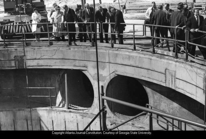 Visitors to Thiokol in 1964 look down into depths of giant static firing pit which is 120 feet deep. The pit was originally used to test rockets for space travel. 