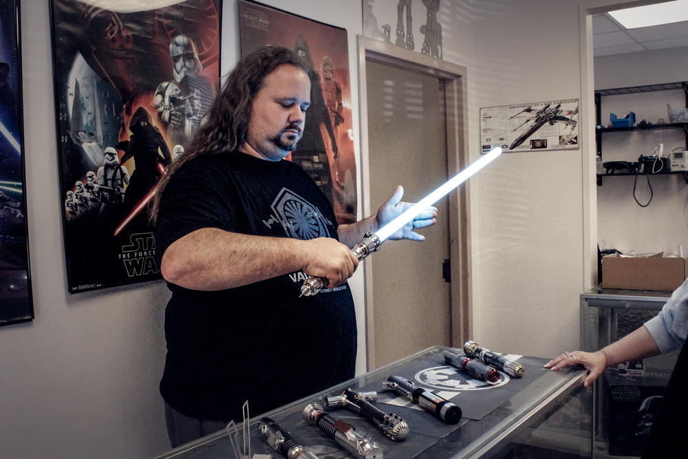 Co-owner Alan Johnson demonstrates one of Vader Vault's lightsabers.