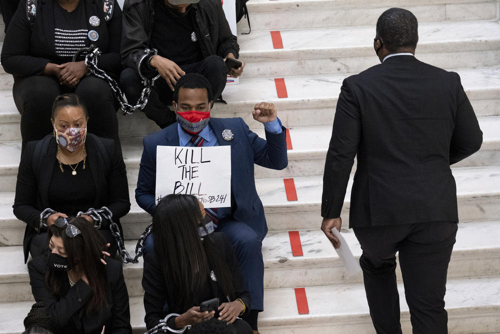 Protesters opposed to changes in Georgia's voting laws sit on the steps inside the State Capitol in Atlanta, Ga., as the Legislature meets Monday, March 8, 2021, in Atlanta. 