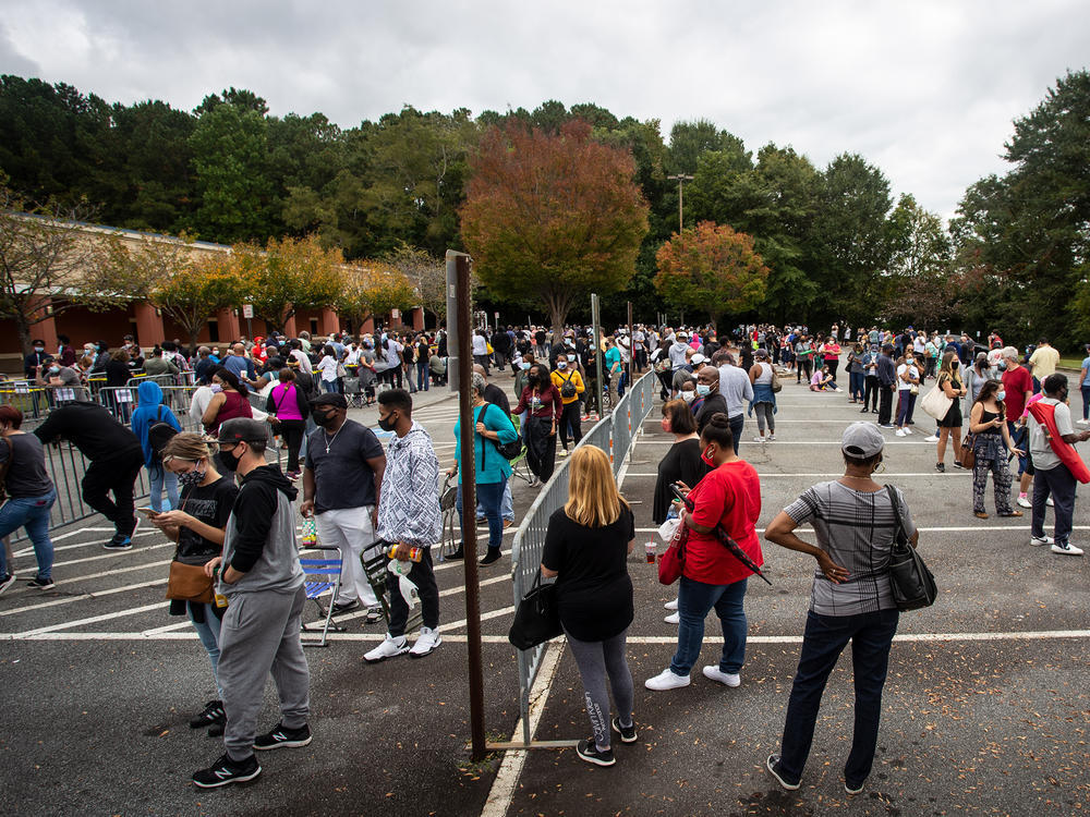 Hundreds of people wait in line for early voting on Monday, Oct. 12, 2020, in Marietta, Georgia. Eager voters have waited six hours or more in the former Republican stronghold of Cobb County, and lines have wrapped around buildings in solidly Democratic DeKalb County.