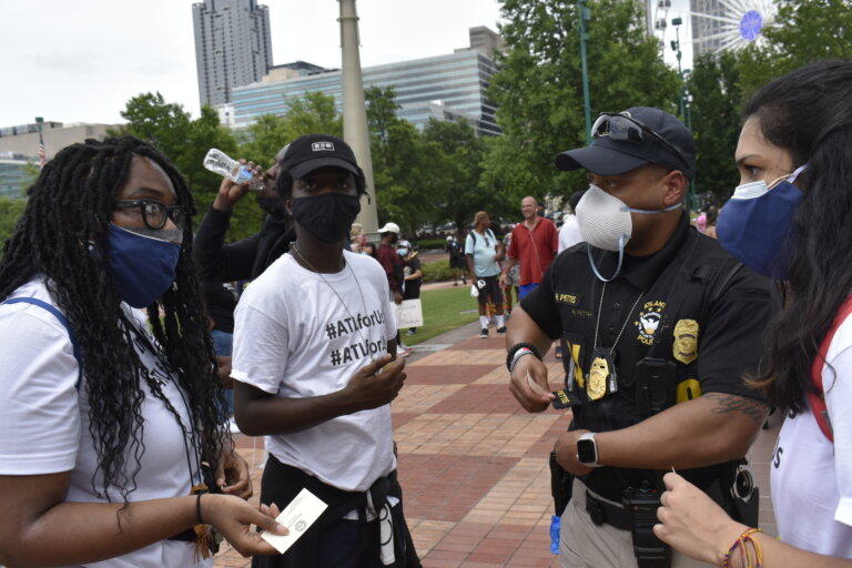 Activist Zoe Bambara, left, speaks with Atlanta Police before a protest she organized last spring. Under a recently-revived bill, organizers would have to submit detailed plans to the cities or counties where they protest.