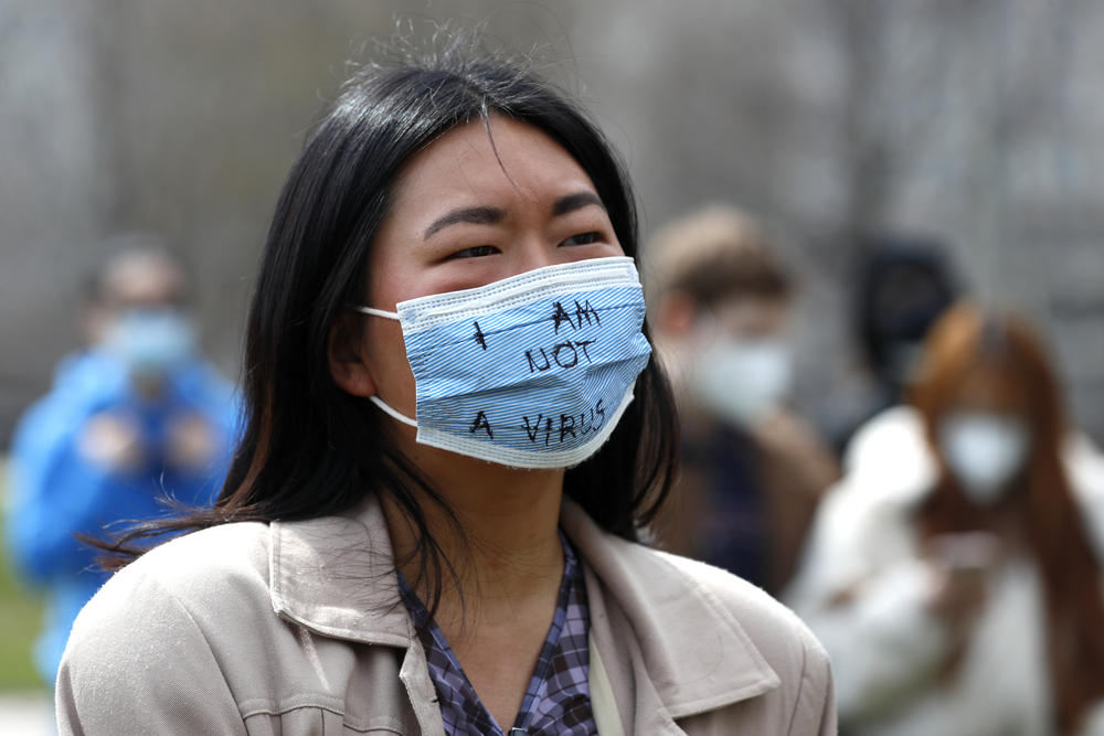 An Asian woman wearing a mask that says "I am not a virus."