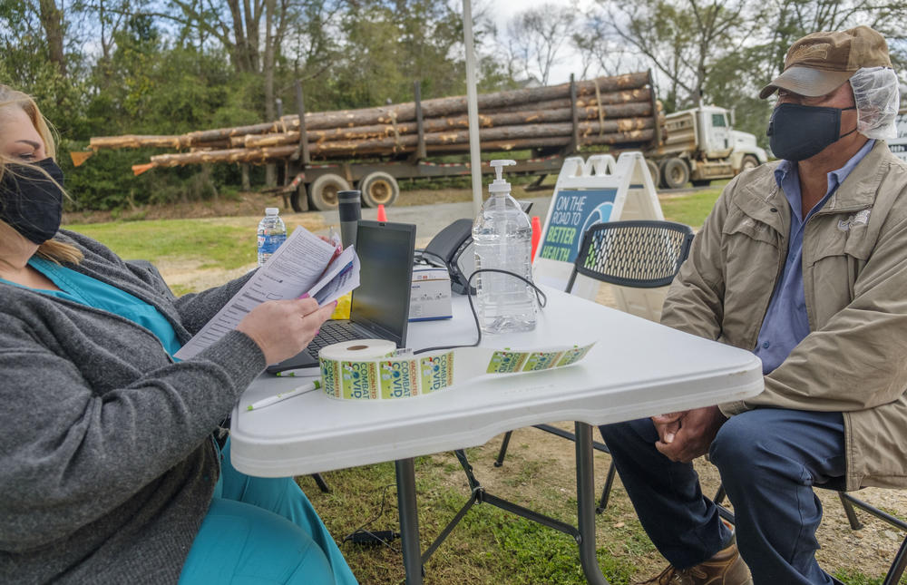 Peanut farmer Gerue Reliford, Jr. gets checked into the mobile vaccine clinic parked in Preston, Ga. recently. Reliford said he'd been anxious to get vaccinated but had to wait for the age limit to drop to 55+. Even so, it was hard to take time from harrowing peanut fields in the spring to make an appointment. The mobile clinic helped. "I just jumped in my truck and came over," Reliford said. 