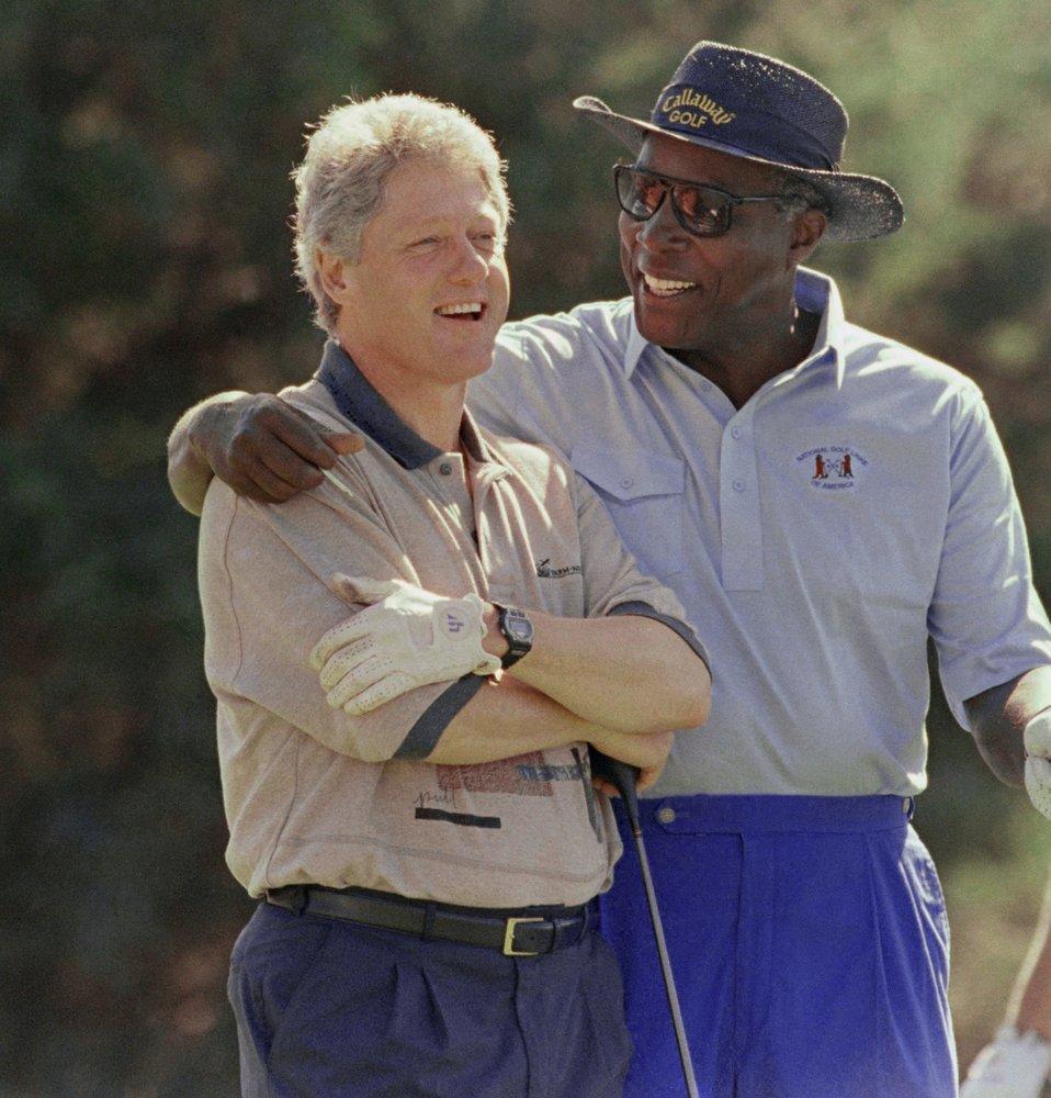 In this Aug. 22, 1993 file photo, President Bill Clinton receives some consoling advice from White House advisor and golf partner Vernon Jordan after Clinton hit a bad shot during their golf math at the Farm Neck Golf Club in Oak Bluffs, Mass., on Martha's Vineyard.