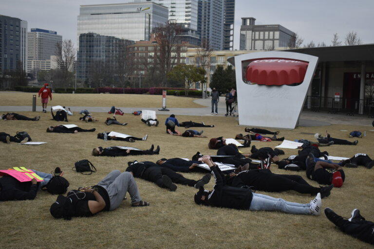 Demonstraters staged a die-in outside the World of Coca-Cola Monday in protest of voting restriction bills in the Georgia Legislature.