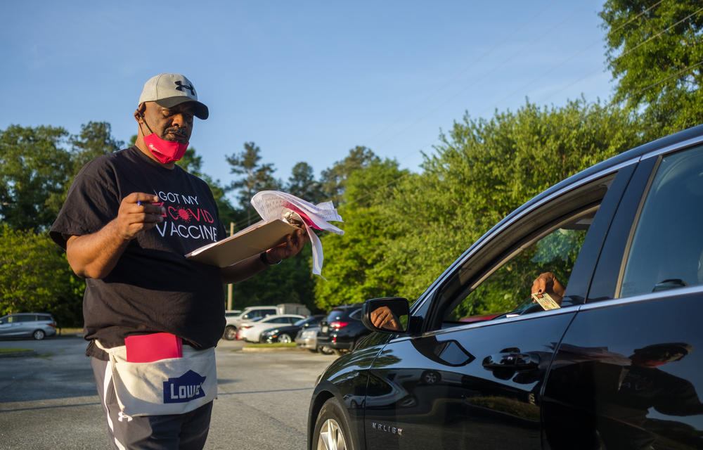 Reverend James Baker tries to a convince someone he checked into into an energy assistance program to also be vaccinated at St. Paul AME in Macon, Tuesday, April 27. Baker said he hears a lot of people say God will keep them safe from COVID-19. He says some of those who have told him that are dead. 