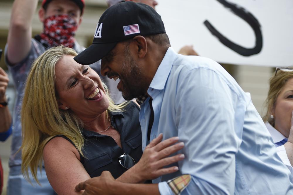 In this Saturday, Nov. 7, 2020 file photo, president Donald Trump supporters cheer as Georgia State Rep. Vernon Jones and Republican Congresswoman-elect Marjorie Taylor Greene embrace during a rally.