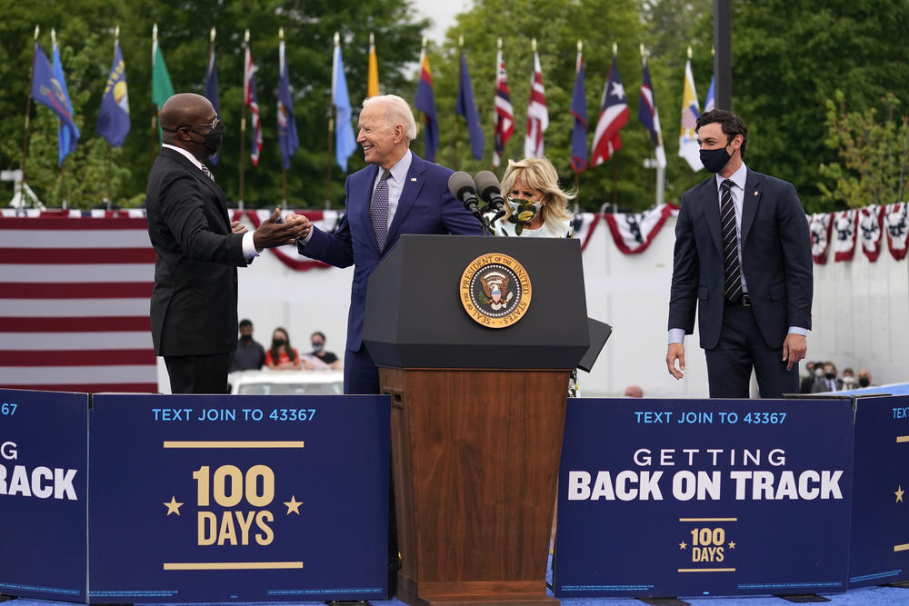 Biden, Ossoff and Warnock on stage talking to each other in Duluth during Biden's visit.