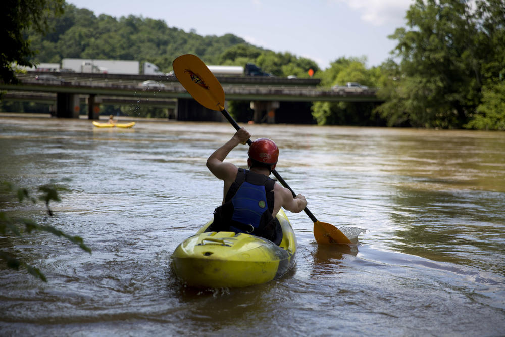 Michael Sorenson launches his kayak down the Chattahoochee river as traffic spans Interstate 285 in Atlanta, Wednesday, June 27, 2018.