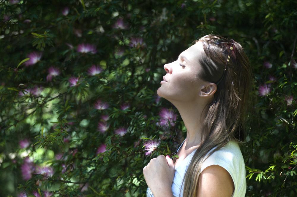 Woman with eyes closed faces sunshine