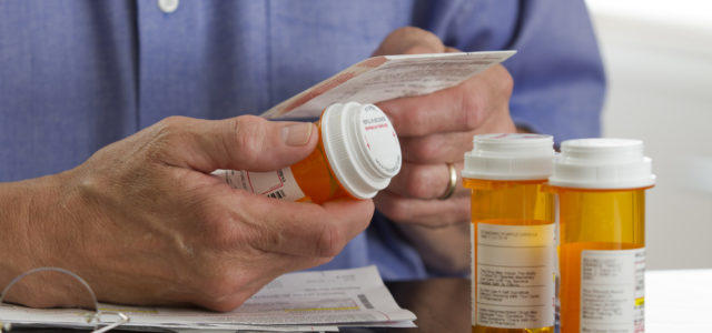 Person holding prescription drug bottles.