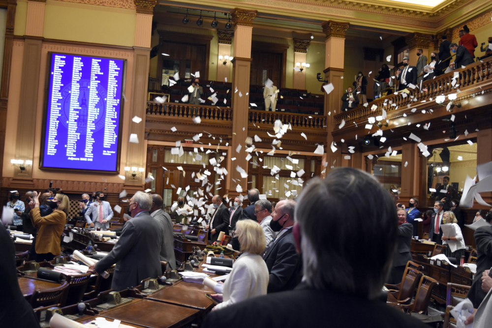 Lawmakers through paper in the air at the end of session.