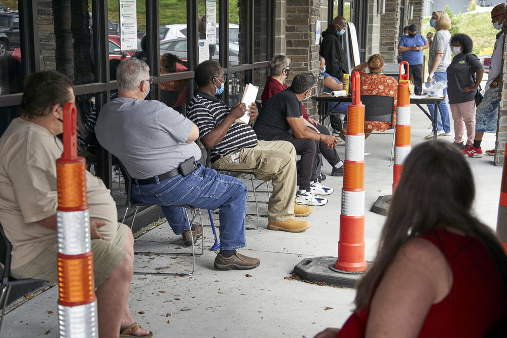 A group of people sit in line.