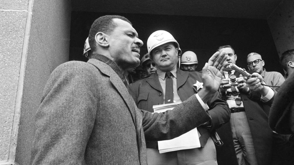 A young C.T. Vivian preaches in front of a sheriff officer in this black and white photo from 