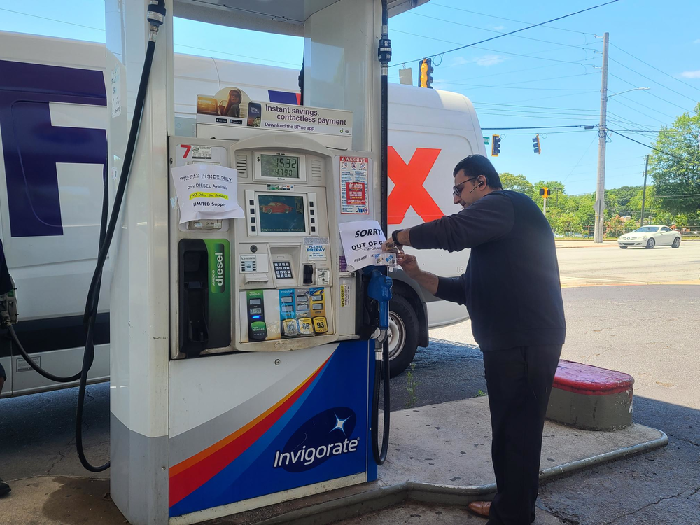 Gas attendant tapes 'Sorry out of gas' sign to pump alerting customers only diesel is available.