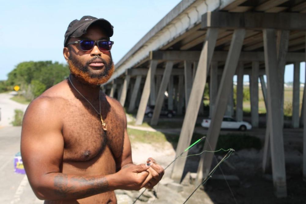 Jake Grant baits his hook at a bridge over the Mackay River on a recent balmy Tuesday afternoon.