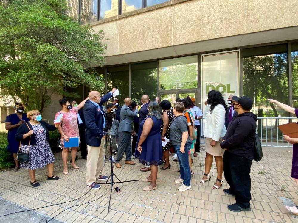 State lawmakers and worker advocates shout, “Open up these doors!” during a protest outside the Georgia Department of Labor office in Atlanta on May 19, 2021. 