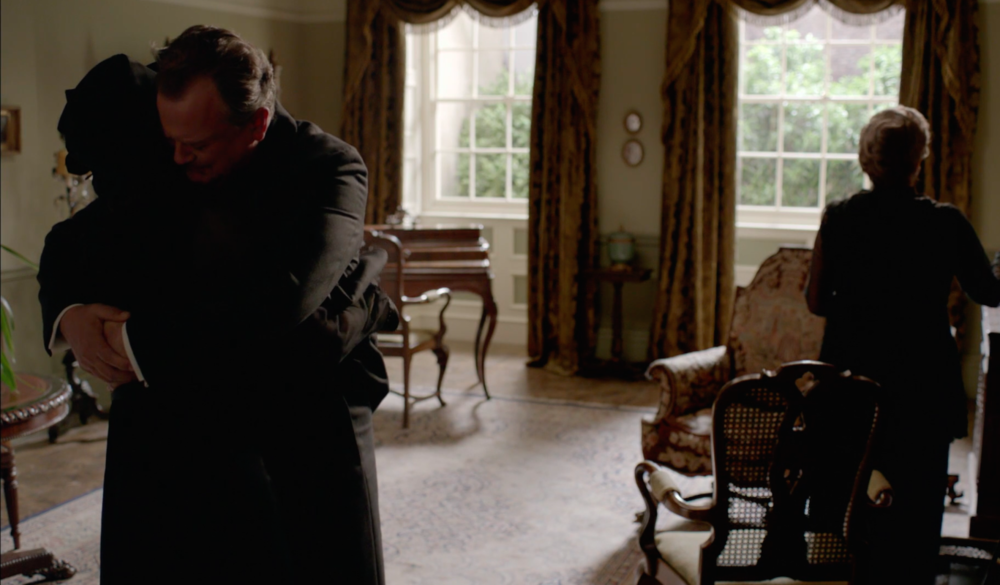 Cora and Robert hug.