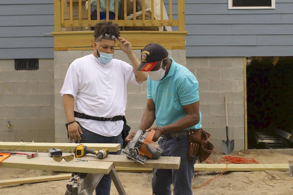 Bibb construction teacher Richard Vaughn explains the techniques of framing a door to student Braijon Jones.