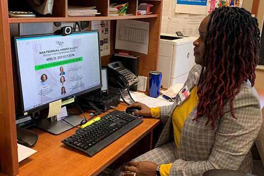 Rose Horton sits at a desk and looks at a computer screen