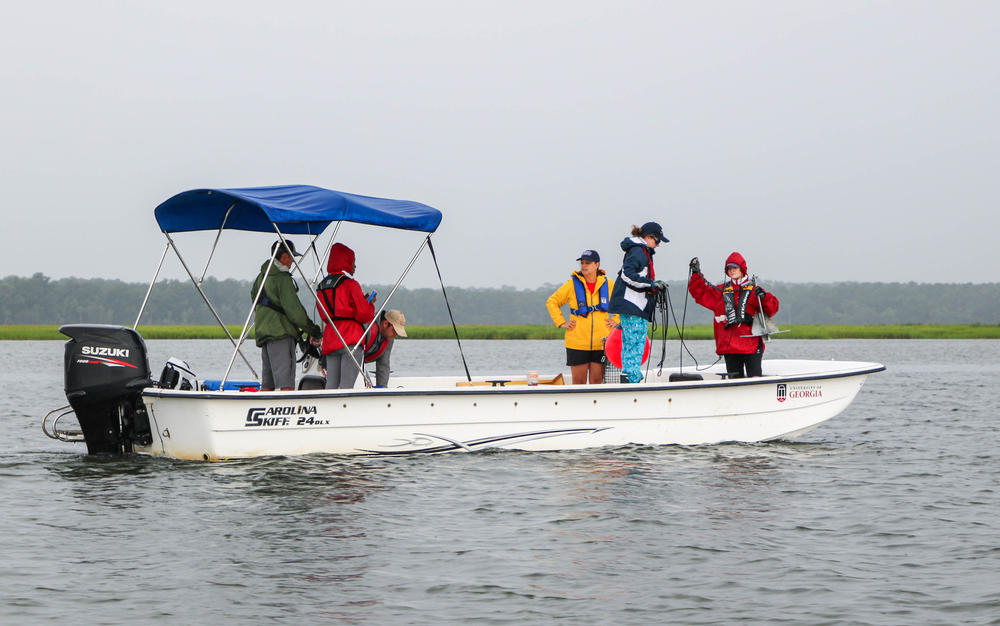 a small group of people in rain gear on a skiff