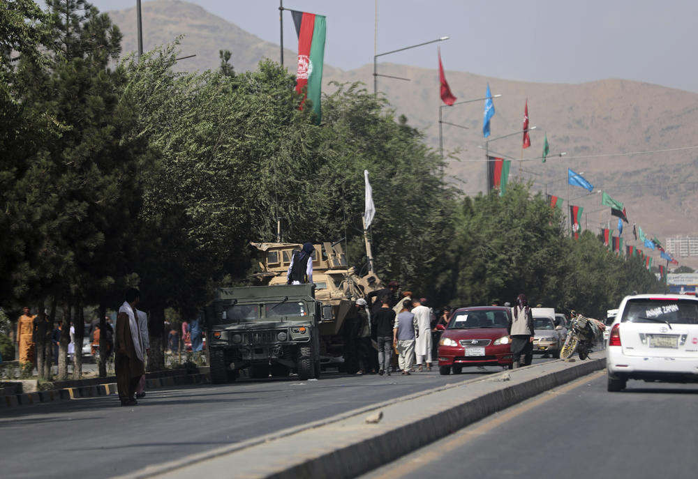Taliban fighters stand guard on the road leading to the Hamid Karzai International Airport, in Kabul, Afghanistan, Monday, Aug. 16, 2021.